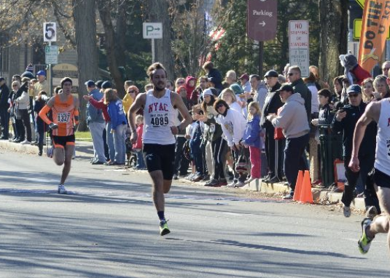 two male runners racing with crowd cheering