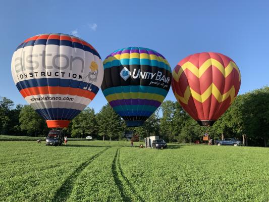 3 hot air balloons getting ready to lift off